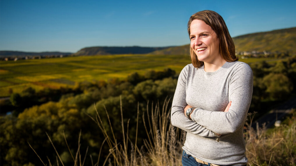 Catherina Grans steht in erhöhter Lage mit Ausblick auf die Weinberge