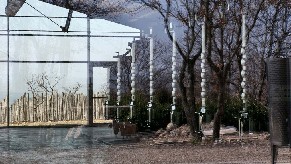 Halle mit Stahltanks, aufgenommen durch eine Glasscheibe