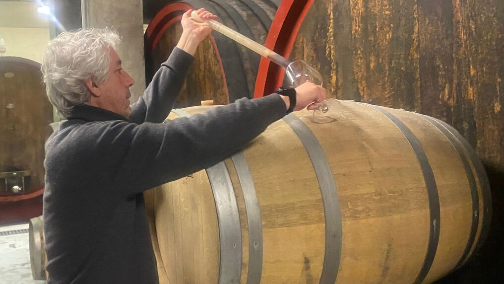 Gabriele Scaglione nimmt eine Probe aus einem Holzfass