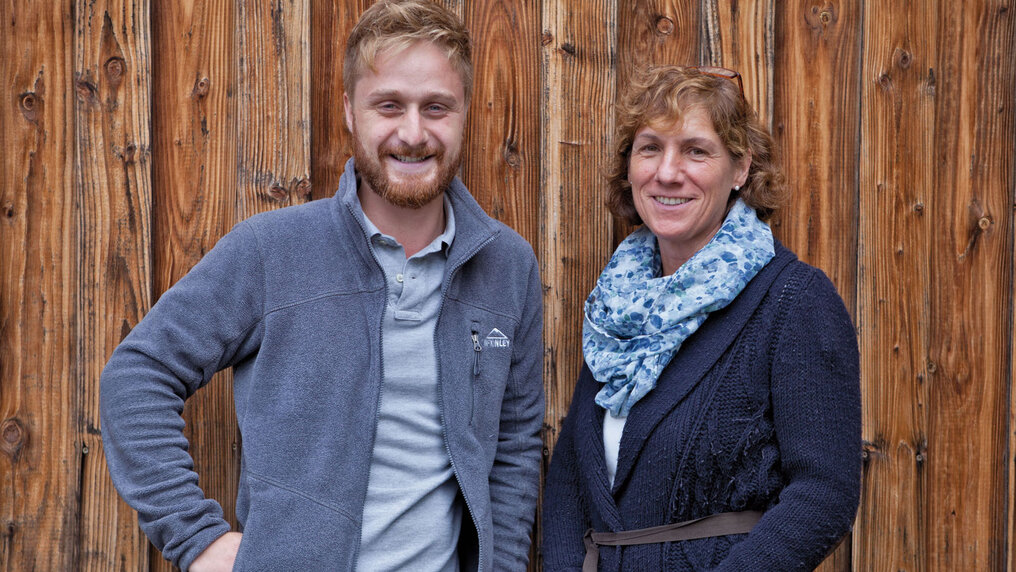Portrait von Julian Huber zusammen mit Mutter Barbara Huber vor einer Holzwand