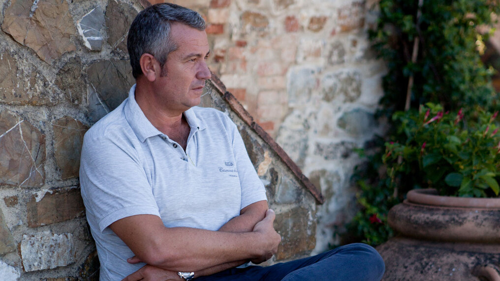 Ciacomo Neri sits leaning against the stone wall of the staircase leading to the manor house.