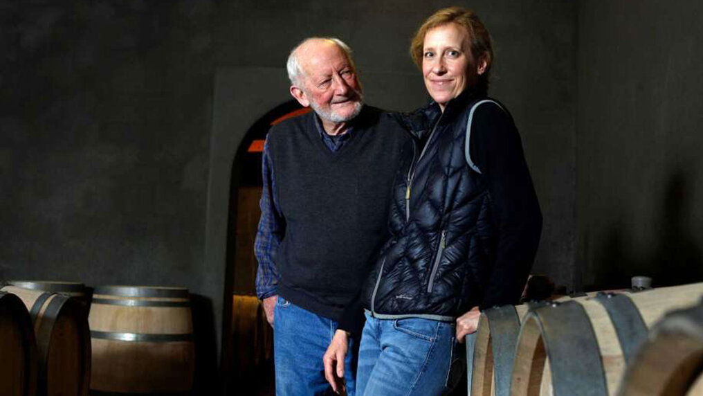 Lisa and her father Philip Togni stand in front of barrique barrels in the cellar of their winery