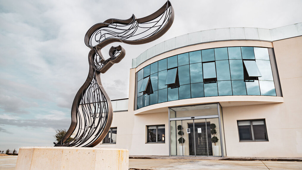 View of the modern bodega with a sculpture of Pandora in front of the entrance.